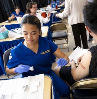 student smiling while vaccinating