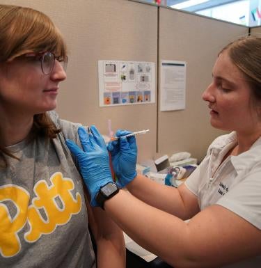 Pitt Student gets the latest Pfizer COVID-19 vaccine from a medical technician at the Pitt Vaccination and Health Connection Hub on 5th Ave.