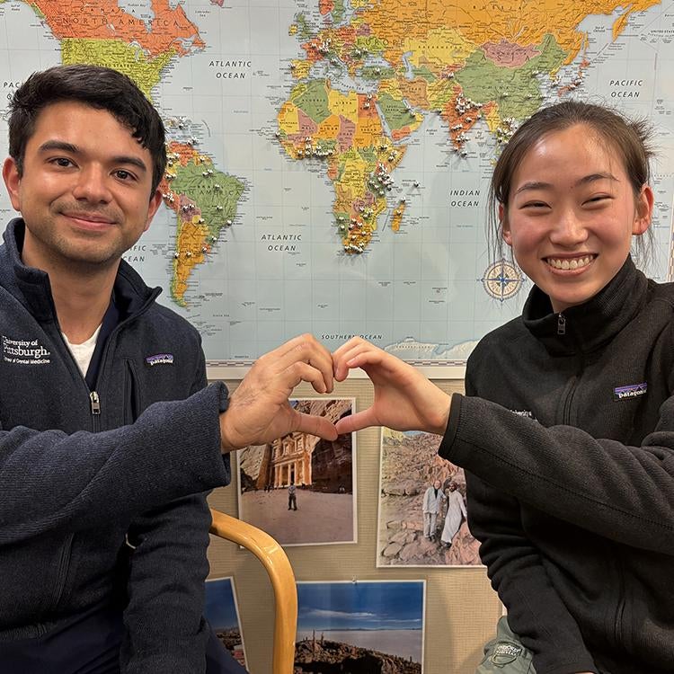 Two people making a heart shape with their hands